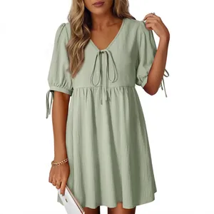 Loose sage green V-neck mini dress featuring puff sleeves and front tie details