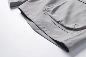 Close-up detail of grey outdoor shorts showing durable stitching and pocket fabric texture