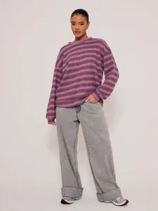 Detail shot of a fashion model wearing an oversized purple striped crewneck sweatshirt.
