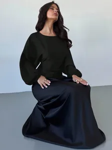 Elegant black satin blouse featuring batwing sleeves and a round neck for autumn style.