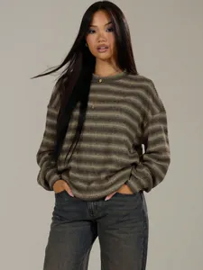 Professional shot of woman wearing oversized striped crewneck knit sweater in earthy tones