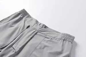 Detail showing grey quick-dry fabric texture and elastic waistband of men's cargo shorts