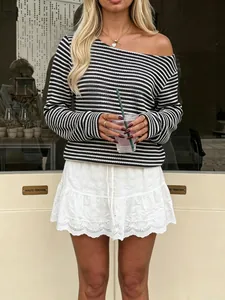 Close-up of black and white pineapple texture striped long sleeve top and white eyelet skirt