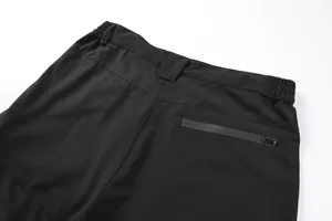 Detail of black tactical cargo pants showing elastic waist and back zipper pocket