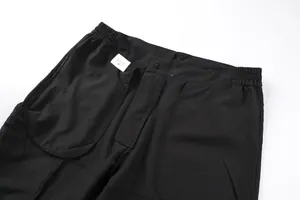 Detail showing the elastic waistband and inner material tag of black men's cargo shorts