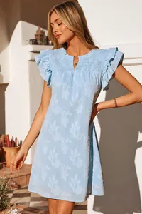 Detailed view of light blue smocked V-neck dress with ruffled sleeves and floral pattern