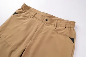 Detail of men's khaki tactical cargo pants showing elastic waist and pocket design.