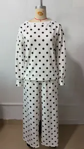 Two-piece white and black polka dot loungewear set with boat neck sweatshirt and trousers.