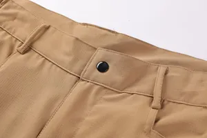 Close-up of men's tactical cargo shorts waistband featuring black button and ripstop fabric.
