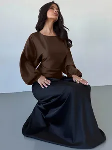 Detail view of the brown satin long-sleeved blouse with round neck and batwing sleeve style