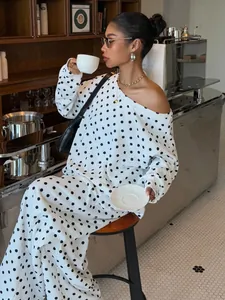 Stylish Asian model in white polka dot slanted collar sweatshirt and pants lounge set.