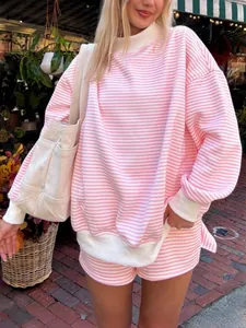 Detail of oversized pink and white striped cotton sweatshirt and shorts set worn outdoors