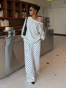 Stylish white polka dot sweatshirt set with off-the-shoulder top and wide-leg trousers.