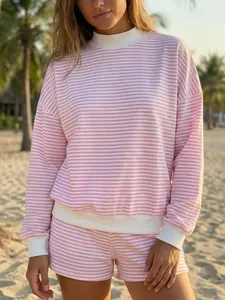 Detailed shot of a pink and white striped cotton sweatshirt set on a sunny beach