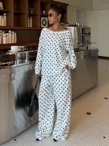 Stylish polka dot loungewear set with slouchy neck top and wide-leg pants in cafe setting