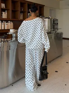 Back view of a chic white polka dot loungewear set featuring slanted collar and wide leg pants