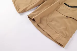 Close-up of functional khaki cargo shorts with zipper and flap pocket detail.