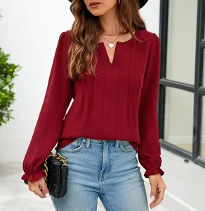 Detailopname van een wijnrode chiffon blouse met V-hals en elegante plooien vooraan