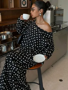 Detail shot of women's black and white polka dot tracksuit set in a cafe setting