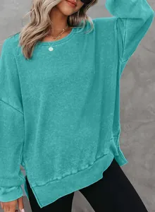 Gedetailleerd beeld van het turquoise wafelgebreide sweatshirt met zijsplitjes onderaan.