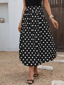Dettaglio di una gonna longuette a pois bianchi e neri con orlo a palloncino chic