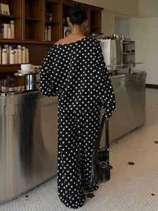 Woman wearing a polka dot lounge set in a cafe setting, showing the back detail.