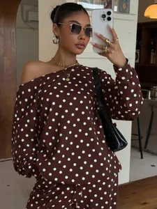 Detail view of the brown polka dot print and slanted neckline on a lounge sweatshirt