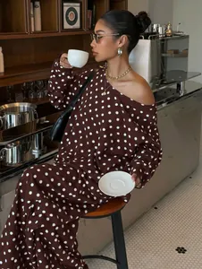 Stylish brown polka dot two-piece lounge set with off-shoulder top in cafe setting.