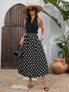 Elegante gonna midi a pois bianchi e neri con vita elastica e orlo svasato.