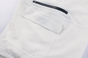 Close-up detail of white men's outdoor cargo shorts featuring a functional zipper pocket