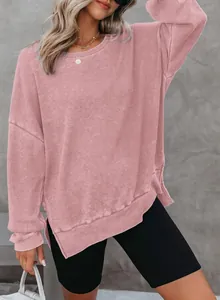 Detailopname van een roze sweatshirt met lange mouwen en wafelgebreid zijsplitontwerp.