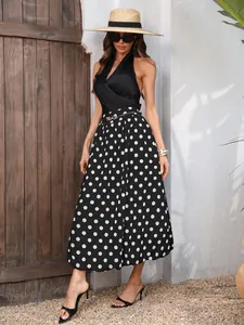 Elegante gonna midi a pois bianchi e neri con silhouette fluida ed elastico in vita.