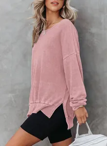 Gedetailleerde weergave van roze wafelgebreide damessweatshirt met zijsplitjes en ronde hals