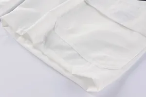 Close-up detail of men's white cargo shorts showing pocket stitching and fabric texture