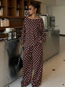 Close-up of brown polka dot two-piece loungewear set worn in a stylish cafe