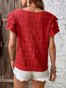 Back view of a vibrant red ruffled sleeve blouse featuring intricate smocked texture.
