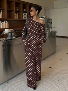 Detail view of a brown polka dot lounge set featuring an off-shoulder top and trousers