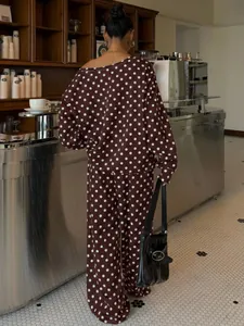 Back view of a casual dark brown polka dot sweatshirt and wide-leg pants set in a cozy cafe.