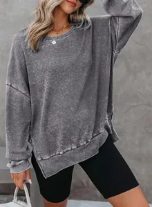 Gedetailleerd overzicht van de wafelstructuur en zijsplit van dit grijze sweatshirt.