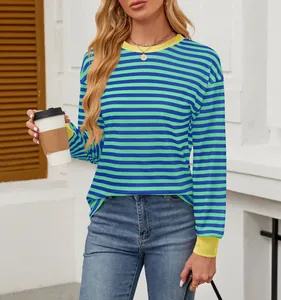 Fashionable woman wearing a green and blue striped long-sleeved top with yellow trim