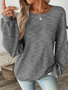 Macro shot of gray waffle knit fabric texture on a loose fit casual long sleeve shirt for women