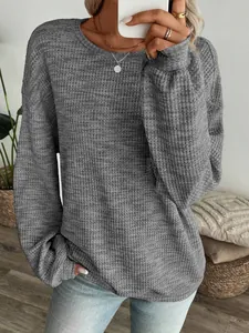 Detailed view of grey waffle knit texture on a loose long-sleeve casual top for women.