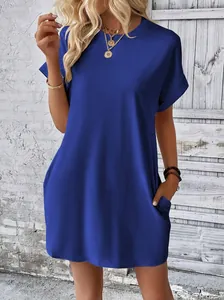 Dettaglio di un abito blu reale ampio a girocollo con maniche corte e tasche.