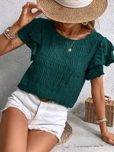 Close-up detail of smocked texture and double ruffle sleeves on a dark green casual top