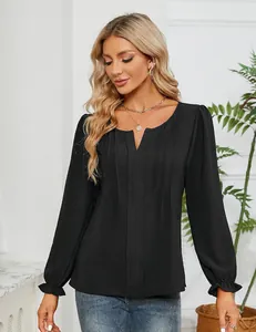 Detailopname van een zwarte chiffon blouse met V-hals, elegante plooien en ruches aan mouwen.