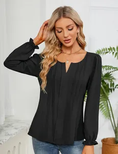 Detailweergave van zwarte chiffon blouse met V-hals en geplooid ontwerp aan de voorkant.