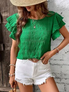 Detailed view of green smocked blouse with double ruffle sleeves and crew neck design.