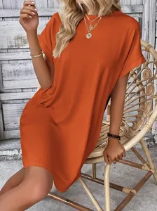 Abito casual ampio color terracotta con scollo rotondo e maniche corte risvoltate.