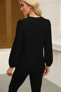 Back view of black chiffon blouse featuring intricate lace patchwork on long sleeves