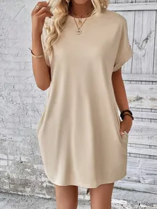 Vista dettagliata di un vestito beige a maniche corte con pratiche tasche laterali.